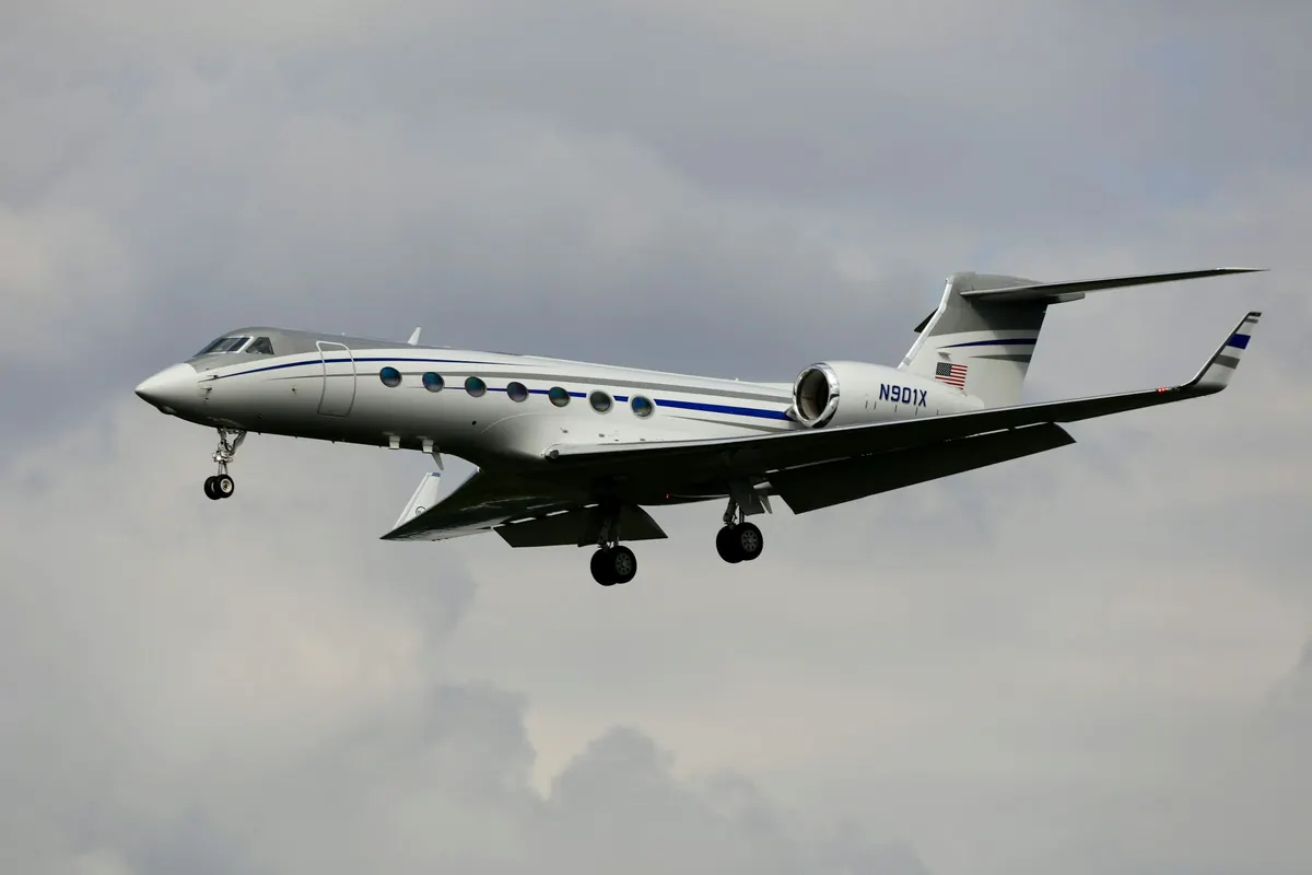 Gulfstream business jet in flight against a soft grey sky